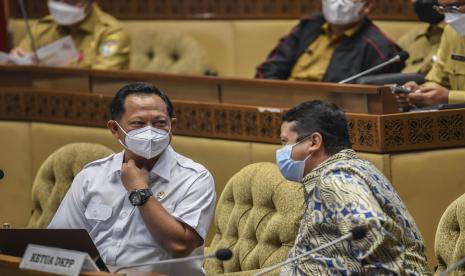 Menteri Dalam Negeri Tito Karnavian (kiri) berbincang dengan Dewan Kehormatan Penyelenggara Pemilu Muhammad (kanan) bersiap mengikuti rapat kerja dengan Komisi II DPR, di Kompleks Parlemen, Senayan, Jakarta, Selasa (5/4/2022). Raker itu membahas evaluasi pelaksanaan program dan anggaran tahun 2021.