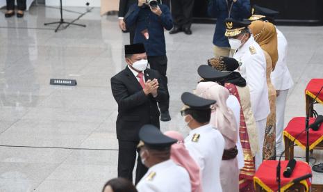 Menteri Dalam Negeri Tito Karnavian (kiri) mengucapkan selamat kepada lima penjabat gubernur yang didampingi istrinya usai dilantik di Kemendagri, Jakarta, Kamis (12/5/2022).