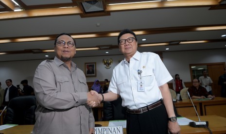 Menteri Dalam Negeri Tjahjo Kumolo (kanan) bersalaman dengan Ketua Pansus RUU Pemilu Lukman Edy (kiri) sebelum memulai rapat di Kompleks Parlemen, Senayan, Jakarta, Rabu (14/6).