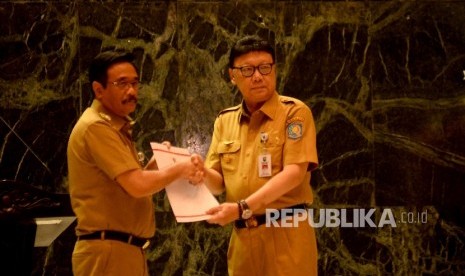 Menteri Dalam Negeri Tjahjo Kumolo memberikan Surat Keputusan Pelaksana Tugas (Plt) Gubernur DKI Jakarta kepada Wakil Gubernur DKI Jakarta Djarot Syaiful Hidayat di Balai Agung, Balaikota, Jakarta, Selasa (9/5).