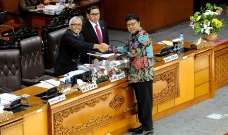 Menteri Dalam Negeri Tjahjo Kumolo menyerahkan RUU tentang pemilihan kepada daerah dan pemerintahan daerah kepada Wakil Ketua DPR RI, Agus Hermanto dalam rapat paripruna di Gedung DPR RI, Jakarta, Selasa (20/1). (Republika/Agung Supriyanto)