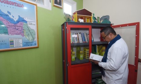 Menteri Desa, Pembangunan Daerah Tertinggal dan Transmigrasi Eko Putro Sandjojo membaca buku pada perpustakaan yang dibangun dengan pemanfaatan dana desa di Desa Ayula Selatan, Kecamatan Bulango Selatan, Kabupaten Bone Bolango, Gorontalo, Jumat (13/1).