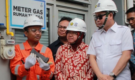 Menteri Energi dan Sumber Daya Mineral (ESDM) Ignasius Jonan (kanan) didampingi Wali Kota Surabaya Tri Rismaharini (kedua kanan) menyimak penjelasan teknisi PT Perusahaan Gas Negara (PGN) (Persero) Tbk usai Peresmian Jaringan Gas Bumi Kota Surabaya di Rumah Susun Penjaringan, Surabaya, Jawa Timur, Minggu (7/5).