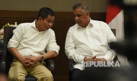 Menteri ESDM Ignasius Jonan (kiri) berbincang dengan Direktur Utama PT PLN (Persero) Sofyan Basir (kanan) di sela-sela melakukan jumpa pers penetapan harga Bahan Bakar Minyak (BBM) dan tarif listrik di Jakarta, Rabu (27/12).