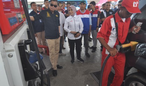 Menteri ESDM Ignasius Jonan (kiri) bersama Dirut Pertamina Nicke Widyawati (kedua kiri) meninjau pengisian bahan bakar minyak (BBM) pada salah satu SPBU saat kunjungan kerja di Palu, Sulawesi Tengah, Jumat (19/10/2018).