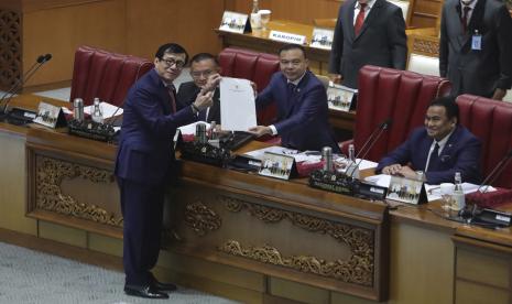 Menteri Hukum dan Hak Asasi Manusia Yasonna Laoly, kiri, berpose untuk media bersama Wakil Ketua DPR Sufmi Dasco Ahmad, tengah, dalam sesi pengesahan KUHP baru di gedung parlemen di Jakarta, Indonesia, Selasa, 6 Desember 2022 Parlemen Indonesia meloloskan revisi KUHP yang telah lama ditunggu-tunggu dan kontroversial pada hari Selasa yang mengkriminalkan seks di luar nikah bagi warga negara dan sama-sama mengunjungi orang asing. 