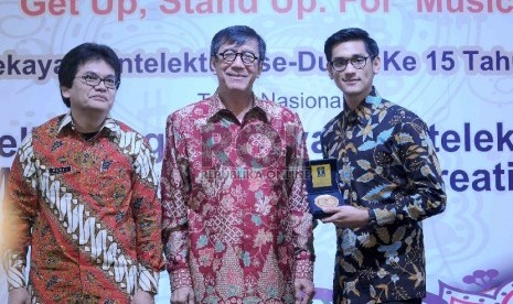 Menteri Hukum dan HAM Yasonna Laoly (tengah) menobatkan musisi Afgan Syah Reza (kanan) menjadi Duta HKI 2015 saat hari Hak Kekayaan Intelektual (HKI) sedunia ke 15 di Kementerian Hukum dan Ham, Jakarta, Kamis (7/5). (Republika/Agung Supriyanto)