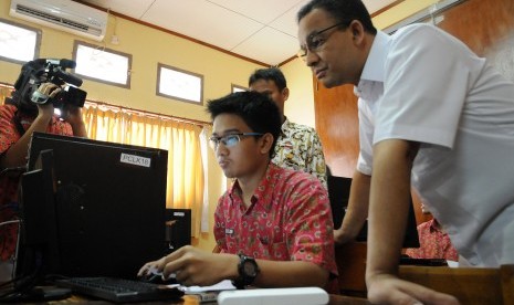 Menteri Kebudayaan, Pendidikan Dasar dan Menengah Anies Baswedan (kanan) memantau jalannya simulasi Ujian Nasional Berbasis Komputer (Computer Based Test) di SMAN 1 Depok, Jawa Barat, Kamis (2/4). 