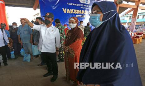 Menteri Kelautan dan Perikanan (KKP) Sakti Wahyu Trenggono (tengah) berbicara dengan warga saat meninjau pelaksanaan vaksinasi bagi nelayan di tempat pelelangan ikan Misaya Mina, Eretan Wetan, Kandanghaur, Indramayu, Jawa Barat, Senin (9/8/2021). Selain melakukan peninjauan vaksinasi, Menteri KKP juga memberikan bantuan sembako bagi nelayan yang terdampak Pandemi COVID-19. 