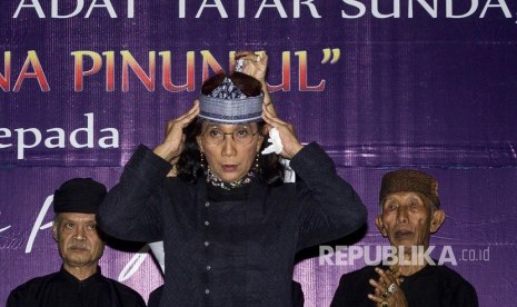 Menteri Kelautan dan Perikanan Susi Pudjiastuti (tengah) disaksikan Baresan Olot (Dewan Kasepuhan) Masyarakat Adat Jawa Barat menerima gelar kehormatan di Gedung Mina Bahari III, Kantor Kementerian Kelautan dan Perikanan, Jakarta, Rabu (19/7). 