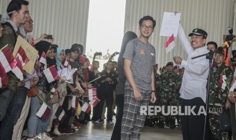 Menteri Kesehatan Terawan Agus Putranto (kanan) menyerahkan surat pernyataan sehat kepada perwakilan Warga Negara Indonesia (WNI) yang telah menjalani masa observasi usai dievakuasi dari Wuhan, Provinsi Hubei, China di Hanggar Pangkalan Udara TNI AU Raden Sadjad, Ranai, Natuna, Kepulauan Riau, Sabtu (15/2/2020).