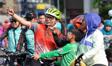  Menteri Ketenagakerjaan Hanif Dhakiri memotret diri sendiri (selfie) dengan warga saat bersepeda di hari Bebas Kendaraan Bermotor di Bundaran HI, Jakarta, Ahad (23/11). 