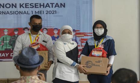 Menteri Ketenagakerjaan Ida Fauziyah (tengah) memberikan paket lebaran kepada tenaga kesehatan dan non kesehatan di Rumah Sakit Darurat Penanganan COVID-19 Wisma Atlet Kemayoran, Jakarta, Sabtu (1/5/2021). Dalam rangka memperingati Hari Buruh Internasional, BPJAMSOSTEK memberikan bantuan paket Ramadhan kepada 1.600 tenaga kesehatan serta memberikan dana perlindungan jaminan sosial kepada 2.404 tenaga kesehatan dan non kesehatan sebagai bentuk solidaritas sesama pekerja.