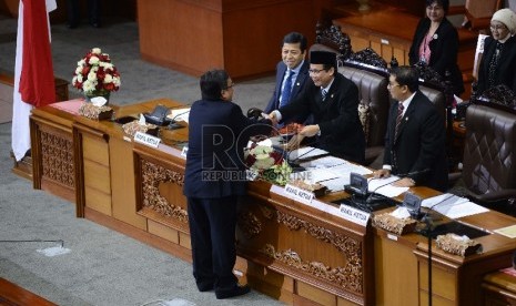   Menteri Keuangan Soemantri Brodjonegoro memberikan berkas pandangan pemerintah kepada Wakil Ketua DPR Taufik Kurniawan selaku pimpinan sidang saat Sidang Paripurna Ke-37 di Kompleks Parlemen, Jakarta, Selasa (7/7). (Republika/Raisan Al Farisi)