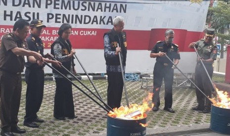 Menteri Keuangan, Sri Mulyani, didampingi, Dirjen Bea Cukai, Heru Pambudi, Gubernur Jawa Tengah, Ganjar Pranowo serta Kepala Bea Cukai Wilayah Jawa tengah dan DIY, Parjiya melakukan pemusnahan secara simbolis barang hasil penindakan Bea Cukai Wilayah Jawa Tengah dan DIY, di Semarang, Rabu (12/12).      