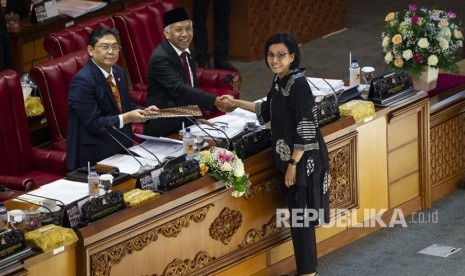 Menteri Keuangan Sri Mulyani Indrawati (kanan) berjabat tangan dengan Wakil Ketua DPR Agus Hermanto seusai menyampaikan tanggapan Pemerintah pada Rapat Paripurna DPR di Kompleks Parlemen, Senayan, Jakarta, Kamis (4/7/2019). 