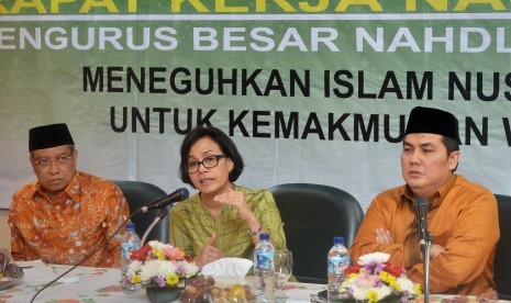 Menteri Keuangan Sri Mulyani Indrawati (tengah) bersama Ketua Umum Pengurus Besar Nahdlatul Ulama (PBNU) Said Aqil Siradj (kiri) dan Sekjen PBNU Helmy Faishal Zaini (kanan) memaparkan materi Tax Amnesty saat Rapat Kerja Nasional (Rakernas) PBNU. 