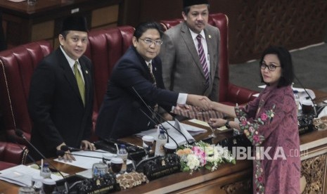 Menteri Keuangan Sri Mulyani (kanan) memberikan hasil tanggapan pemerintah kepada Ketua Sidang Utut Adianto (kedua kiri), disaksikan Ketua DPR Bambang Soesatyo (kiri) dan Wakil Ketua DPR Fahri Hamzah pada Sidang Paripurna DPR di Komplek DPR, Jakarta, Selasa (17/7). 