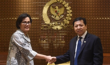 Menteri Keuangan Sri Mulyani (kiri) berjabat tangan dengan Ketua DPR Setya Novanto (kanan) sebelum pertemuan tertutup di Kompleks Parlemen, Senayan, Jakarta, Kamis (19/10).