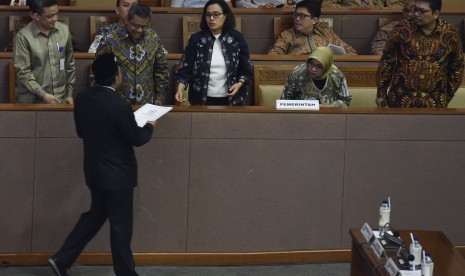 Menteri Keuangan Sri Mulyani (tengah) menerima laporan hasil pembahasan RAPBN 2019 dari Wakil Ketua Banggar DPR Jazilul Fawaid saat Rapat Paripurna ke-30 di Kompleks Parlemen Senayan, Jakarta, Kamis (12/7).