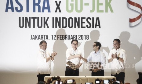 Menteri Komunikasi dan Informatika Rudiantara (kiri) bersama Presiden GO-JEK Andre Soelistyo (kanan) menyaksikan penandatanganan kerja sama Investasi antara Astra Internasional dengan GO-JEK yang dilakukan oleh Presiden Direktur PT Astra International Tbk Prijono Sugiarto (kedua kiri) dan CEO & CO-Founder GO-JEK Nadiem Makariem (kedua kanan) di Jakarta, Senin (12/2). 