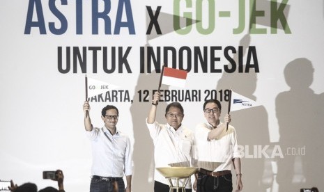 Menteri Komunikasi dan Informatika Rudiantara (tengah) mengangkat bendera bersama Presiden Direktur PT Astra International Tbk Prijono Sugiarto (kanan) dan CEO & CO-Founder GO-JEK Nadiem Makariem (kiri) seusai penandatanganan kerja sama Investasi antara Astra Internasional dengan GO-JEK di Jakarta, Senin (12/2).