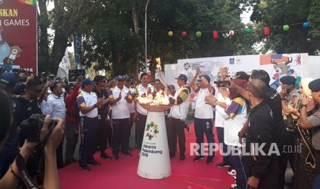 Menteri Koordinator Bidang Kemaritiman Luhut Binsar Panjaitan bersama Gubernur NTB TGB Zainul Majdi menerima api obor yang dibawa Kapolda NTB Brigjen Pol Achmad Juri pada Kirab Obor Asian Games 2018 di depan Pendopo Gubernur NTB, Jalan Pejanggik, Mataram, NTB, Rabu (25/7).