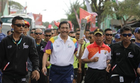 Menteri Koordinator Bidang Kemaritiman, Luhut Binsar Panjaitan membawa obor Asian Games 2018 di NTB, Kamis (26/7).