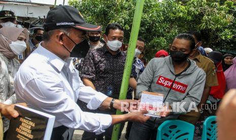 Menteri Koordinator Bidang Pembangunan Manusia dan Kebudayaan Muhadjir Effendy (kiri) menyerahkan langsung bantuan sosial kepada warga.