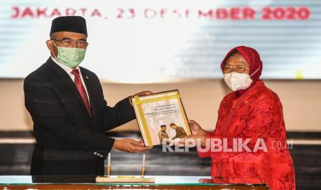 Menteri Koordinator Bidang Pembangunan Manusia dan Kebudayaan yang juga pejabat lama Menteri Sosial Ad Interim Muhajir Effendi (kiri) menyerahkan Memori Jabatan Kementerian Sosial kepada Menteri Sosial Tri Rismaharini (kanan) dalam acara serah terima jabatan di Kantor Kementerian Sosial, Jakarta, Rabu (23/12/2020). Tri Rismaharini resmi diangkat Presiden Joko Widodo menjadi Menteri Sosial menggantikan Juliari Batubara yang tersandung kasus korupsi dana Bantuan Sosial (Bansos). 