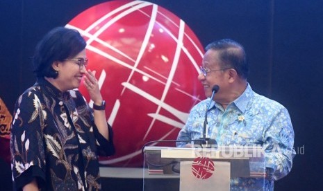 Menteri Koordinator Bidang Perekonomian Darmin Nasution (kanan) berbincang dengan Menteri Keuangan Sri Mulyani (kiri) saat pembukan perdagangan 2019 di Bursa Efek Indonesia, Jakarta, Rabu (2/1/2019).