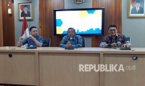 Menteri Koordinator Bidang Perekonomian Darmin Nasution (tengah) bersama Kepala Badan Koordinasi Penanaman Modal (BKPM) Thomas Lembong menjelaskan Online Single Submission (OSS) di Gedung Kemenko Perekonomian, Jumat (25/5).