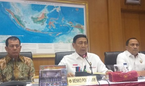 Menteri Koordinator Politik Hukum dan Keamanan Wiranto (tengah) memberikan keterangan pers di Gedung Kemenkopolhukam, Jakarta Pusat, Rabu (21/8).