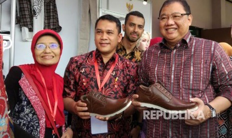 Menteri Koperasi dan UMKM Anak Agung Gede Ngurah Puspayoga memamerkan sepatu hasil produksi pengusaha lokal dalam acara Temu Usaha Wirausaha Pemula, di Hotel Ibis Cawang, Jakarta, Kamis (6/4).