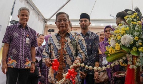 Menteri Kordinator Bidang Perekonomian Darmin Nasution (tengah), memotong pita tanda dibukanya ekspo produk koperasi dan UMKM, pada acara peringatan Hari Koperasi Nasional, di GOR Satria Purwokerto, Banyumas, Jateng, Jumat (12/7/2019). 