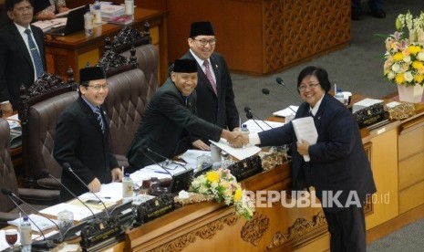 Menteri Lingkungan Hidup dan Kehutanan Siti Nurbaya Bakar (kanan) menyerahkan laporan pengambilan keputusan terhadap Rancangan Undang-Undang tentang konvensi minamata mengenai merkuri kepada pimpinan sidang paripurna DPR Agus Hermanto (kedua kiri), Taufik Kurniawan (kiri) dan Fadli Zon (kanan) di Kompleks Parlemen Senayan, Jakarta, Rabu (13/9).