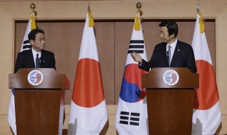 Menteri Luar Negeri Korea Selatan Yun Byung-se (kanan) berbicara dengan Menlu Jepang Fumio Kishida dalam konferensi pers gabungan di Kementerian Luar Negeri di Seoul, Senin, 28 Desember 2015. Keduanya mengatakan Korsel dan Jepang menyepakati solusi budak s