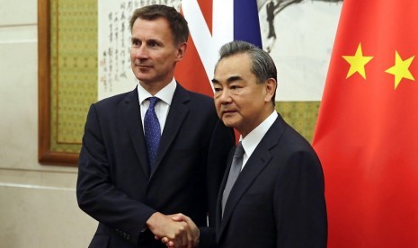  Menteri Luar Negeri (Menlu) Inggris Jeremy Hunt (kiri) berjabat tangan dengan Menlu Cina Wang Yi ketika mereka berpose untuk foto sebelum pertemuan mereka di Wisma Negara Diaoyutai di Beijing, Senin, 30 Juli 2018.