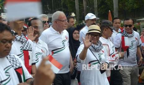 Menteri Luar Negeri (Menlu) RI Retno Marsudi (kedua kanan) dan Menlu Palestina Riyad al-Maliki (tengah)jalan santai bersama dalam acara Walk for Peace and Humanity di kawasan car free day (CFD) Jakarta, Ahad (14/10).