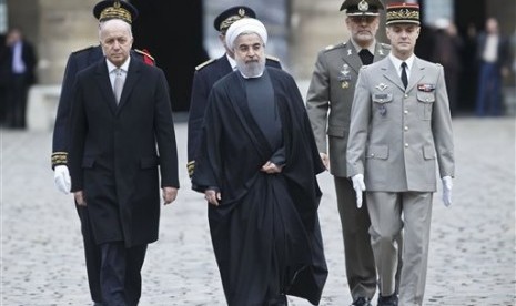 Menteri Luar Negeri Prancis Laurent Fabius (kiri) dan Presiden Iran Hassan Rouhani tiba untuk upacara penyambutan di Invalides, Paris, Kamis, 28 Januari 2016.