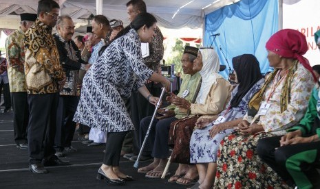 Menteri Menko PMK Puan Maharani (tengah) didampingi Menteri Sosial Idrus Marham (kiri) secara simbolis memberikan bantuan kepada lansia di Markas Komando Paskhas TNI AU, Sleman, DI Yogyakarta, Kamis (5/7). 