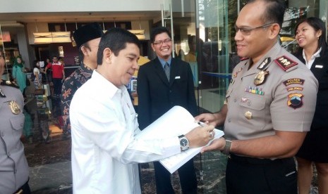  Menteri PANRB Yuddy Chrisnadi didampingi Kapolres Banyumas Gidion Arif Setiawan menyimak aplikasi online untuk perpanjangan SIM dan SKCK di Mapolres Banyumas, Rabu (22/6).