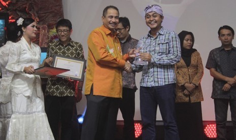 Menteri Pariwisata Arief Yahya (kiri) memberikan penghargaan Anugerah Pesona Bahari 2015 kepada salah seorang pemenang, Erwin Gumilar jurnalis majalah Venue