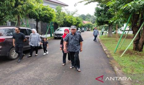 Menteri Pekerjaan Umum dan Perumahan Rakyat (PUPR) Basuki Hadimuljono bersama keluarga menuju TPS 161 di Kemang Pratama Bekasi, Jawa Barat pada Rabu (14/2/2024). 