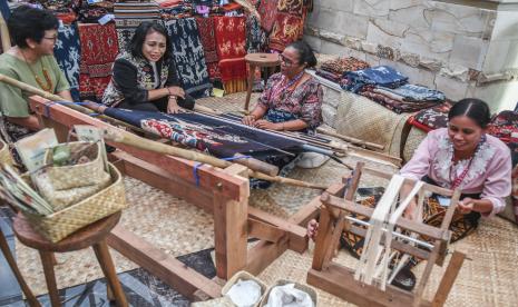 Menteri Pemberdayaan Perempuan dan Perlindungan Anak I Gusti Ayu Bintang Darmawati Puspayoga (kedua kiri) melihat produksi kain tradisional dari Sumba yang dijual di salah satu stan UMKM pada kegiatan Ministerial Conference on Women