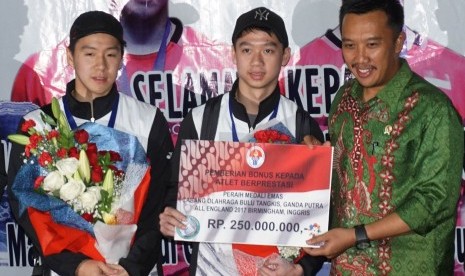 Menteri Pemuda dan Olahraga Imam Nahrawi (kedua kanan) menyerahkan bonus secara simbolik kepada pebulu tangkis peraih gelar juara ganda putra All England, Kevin Sanjaya (tengah) dan Marcus F Gideon (kedua kiri), saat tiba di Terminal 2D Bandara Soekarno Ha