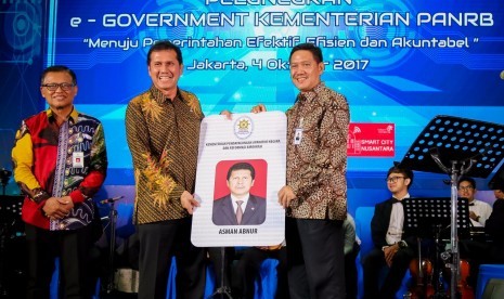 Menteri Pendayagunaan Aparatur Negara dan Reformasi Birokrasi Asman Abnur (kedua kiri) menerima mock-up Kartu Identitas Multifungsi (KIM) dari Direktur Manajemen Risiko Bank BRI Kuswiyoto (kanan) di Jakarta, Rabu (4/10).