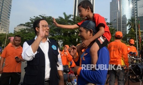 Menteri Pendidikan dan Kebudayaan Anies Baswedan berbincang dengan pengunjung car free day saat sosialisasi kampanye anter anak pada hari pertama sekolah di Patung Kuda, Jakarta, Ahad (17/7). (Republika/Yasin Habibi) 