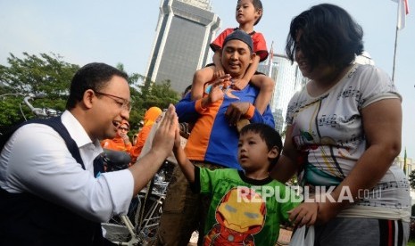 Menteri Pendidikan dan Kebudayaan Anies Baswedan berbincang dengan pengunjung car free day saat sosialisasi kampanye anter anak pada hari pertama sekolah di Patung Kuda, Jakarta, Ahad (17/7). (Republika/Yasin Habibi) 