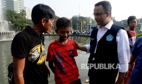 Menteri Pendidikan dan Kebudayaan Anies Baswedan berbincang dengan pengunjung car free day saat sosialisasi kampanye anter anak pada hari pertama sekolah di Patung Kuda, Jakarta, Ahad (17/7). (Republika/Yasin Habibi) 